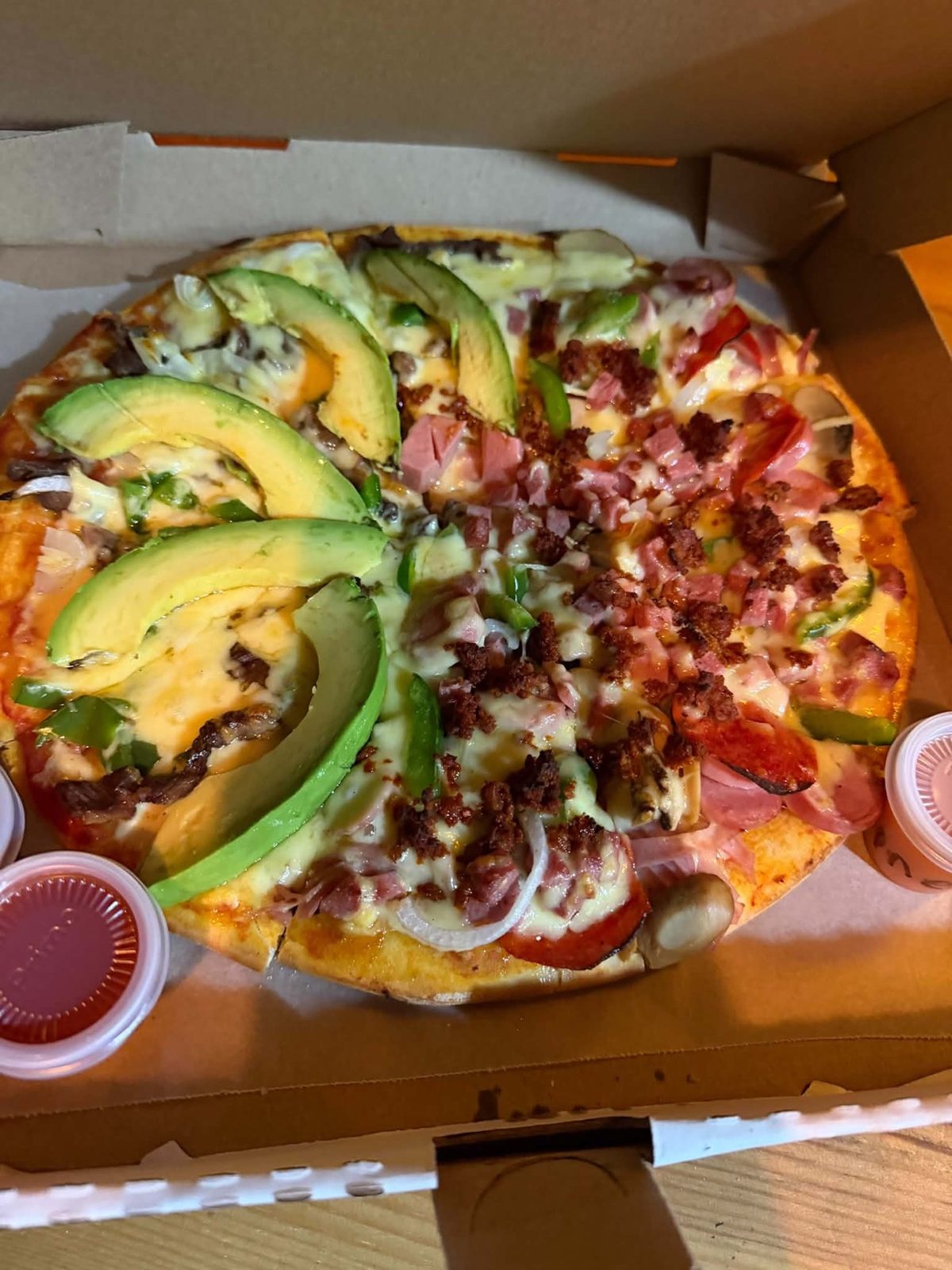 Pizza mitad y mitad en su caja, lista para llevar
